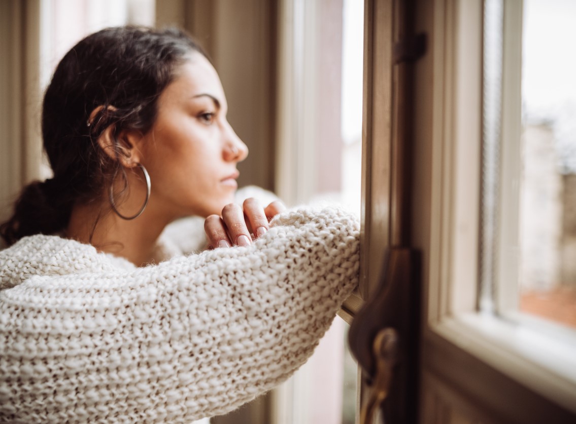 Pensive woman in front of the window