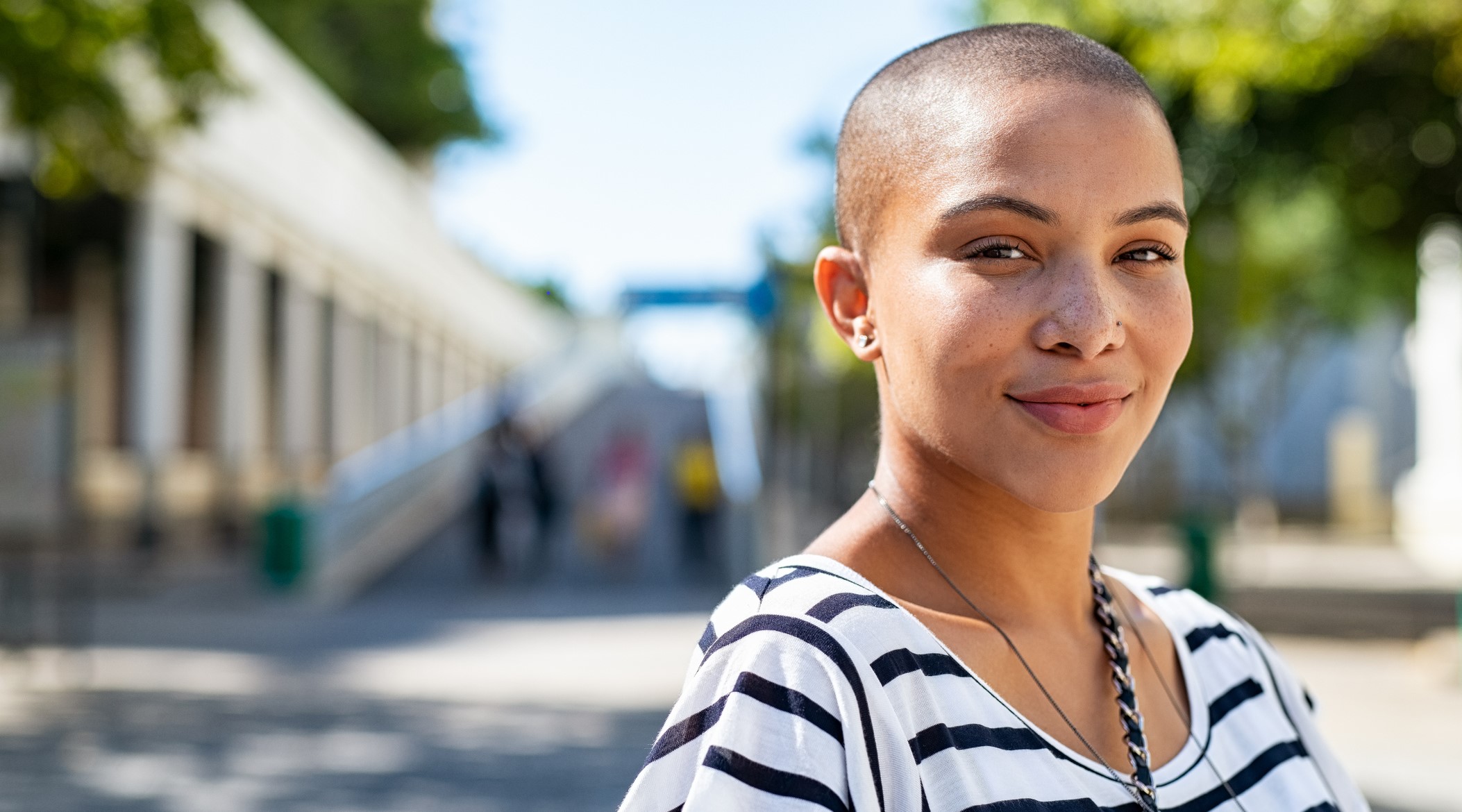 Portrait of young strong multi-racial woman on city street looking at camera