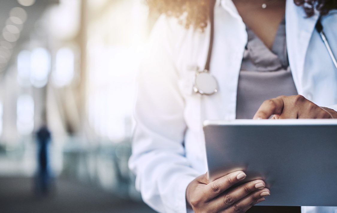 Multi-ethnic female doctor using digital tablet