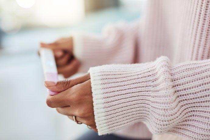 A pair of hands holding a pregnancy test
